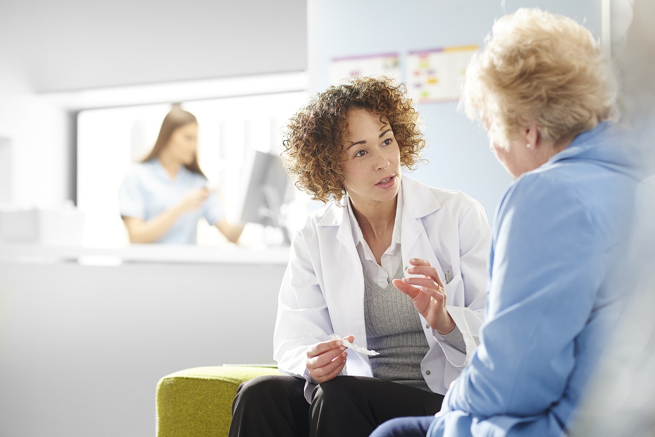 female doctor talking to elderly patient
