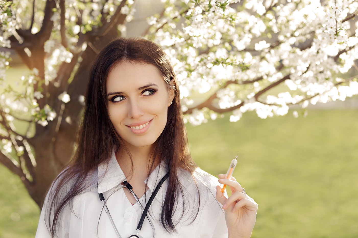 doctor holding a syringe next to a tree