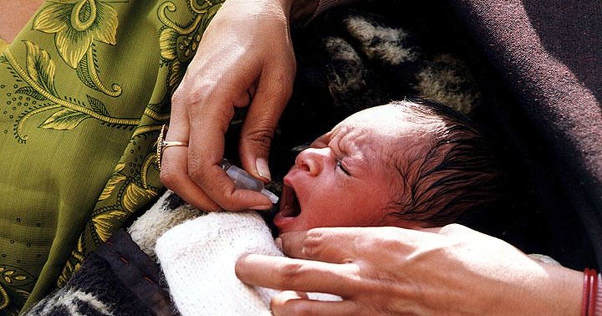 giving oral polio vaccine to baby